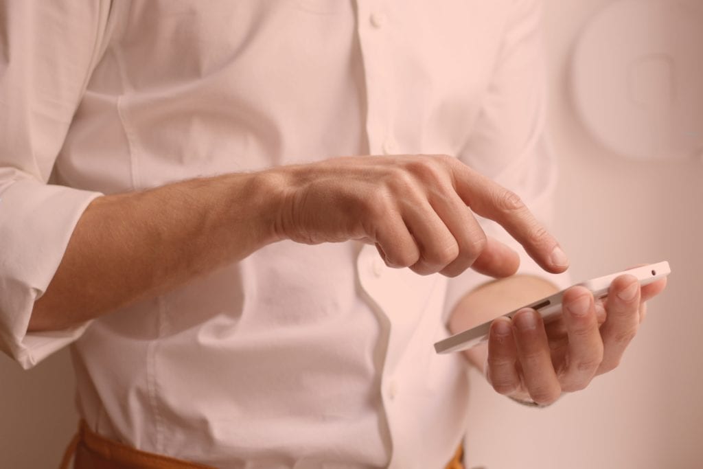 Photo of salesman about to dial a discovery call on his smartphone.
